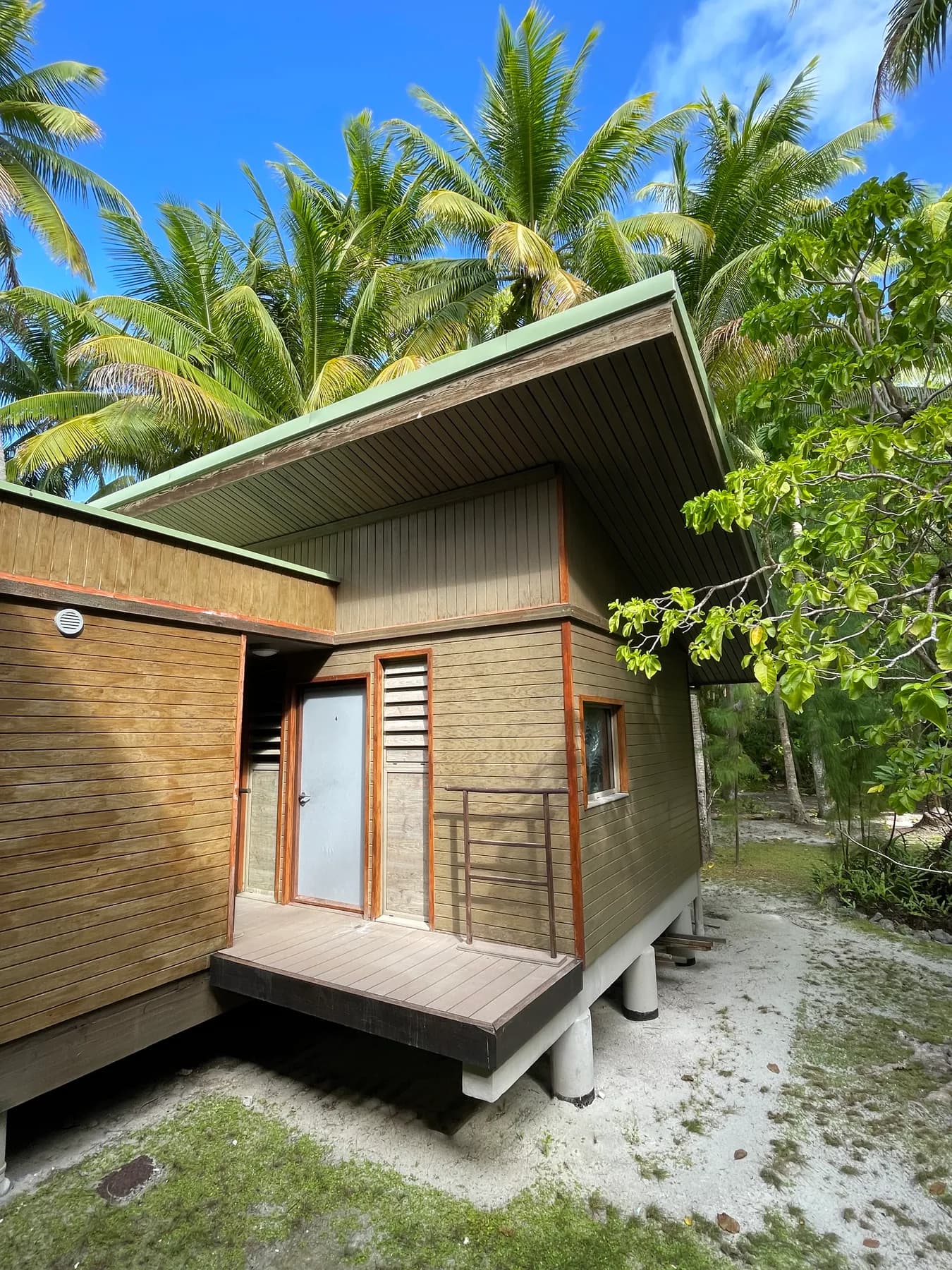 A timber station building and covered walkway among palms
